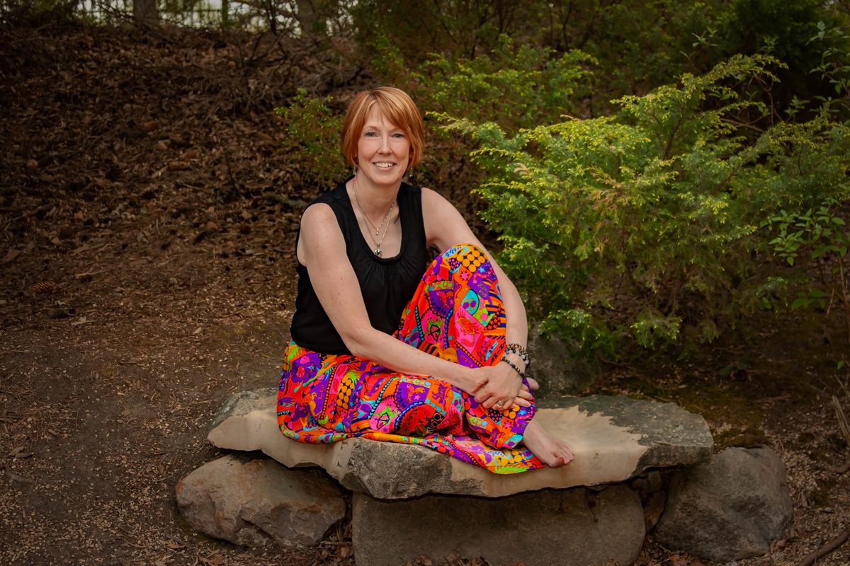 Chris MacPherson sitting on a rock in a natural landscape