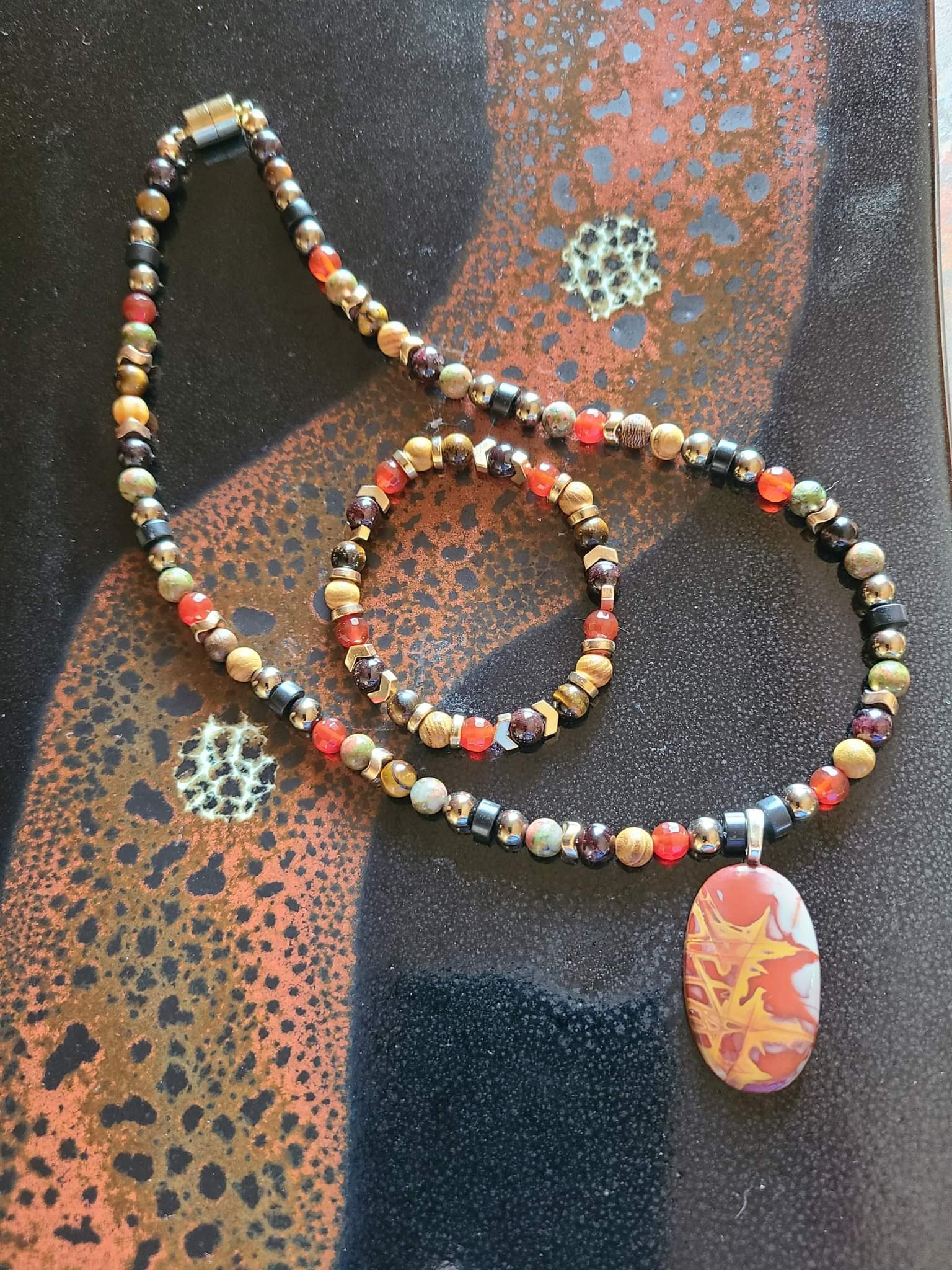 Handmade jasper custom jewelry set resting on natural stone