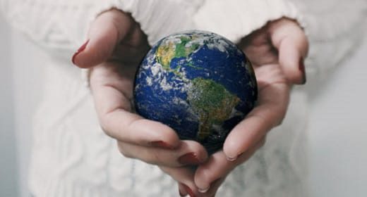 Hands cradling a glowing globe of light